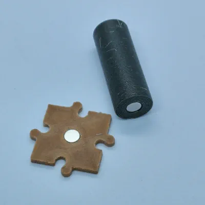 Una peça del tauler i una de joc on es veuen els imans